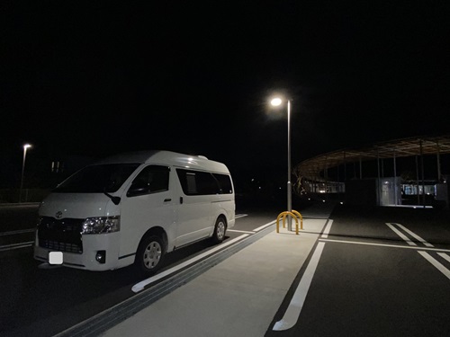 道の駅保田小学校の駐車場夜間照明の下の車