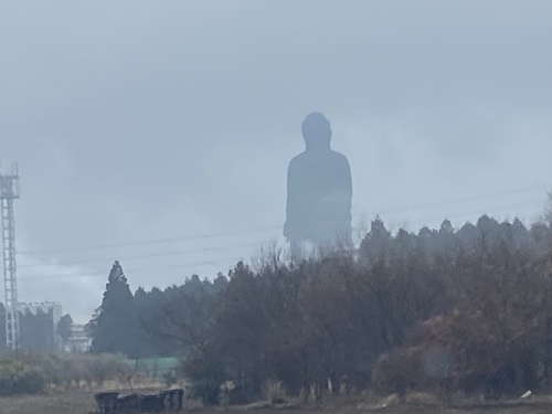 林の向こうに立つ牛久大仏