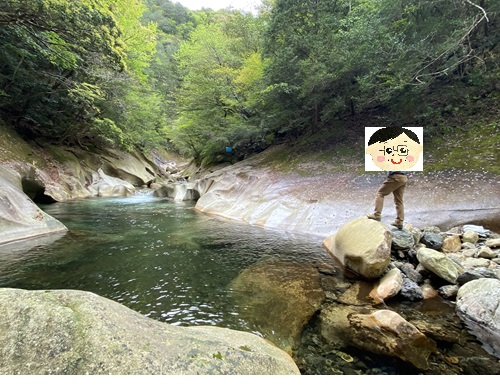 エメラルド淵近くの岩の上に立つ夫さん