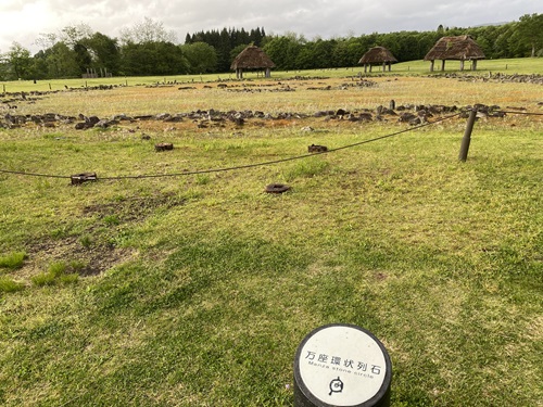 万座環状列石の看板と遠景