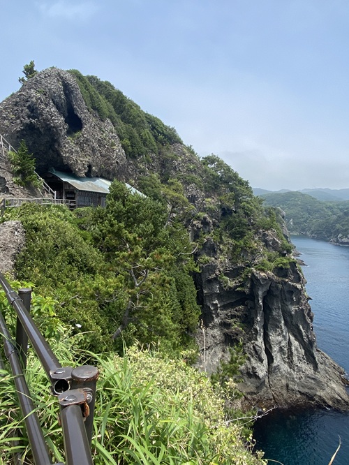 断崖の岩に抱かれる石室神社と青い海