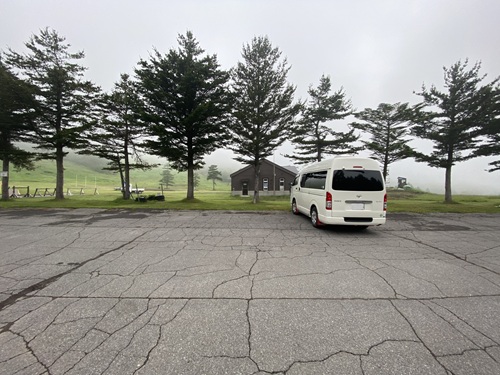 奥にパトロール棟が見える高峰マウンテンパークの駐車場の位置