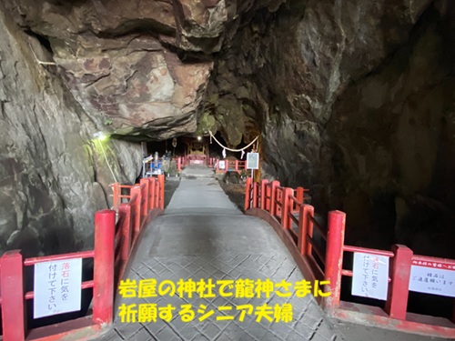 岩屋の神社で龍神様に祈願するシニア夫婦